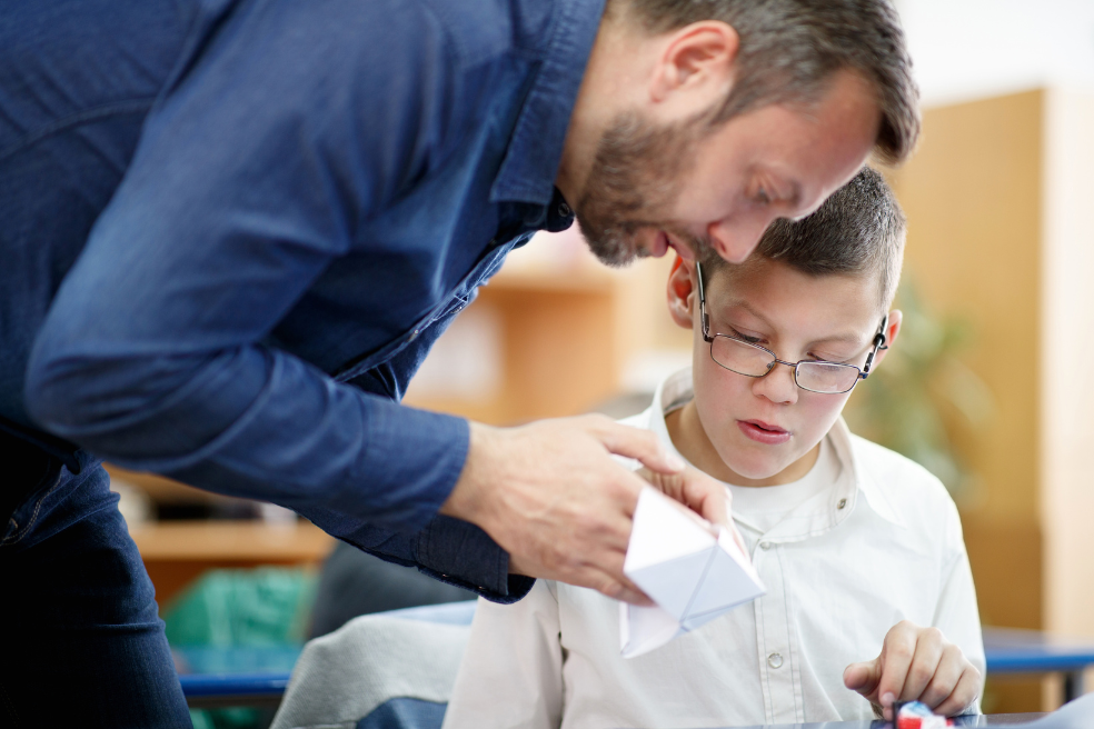 A photo of a male teacher and a special education needs pupil