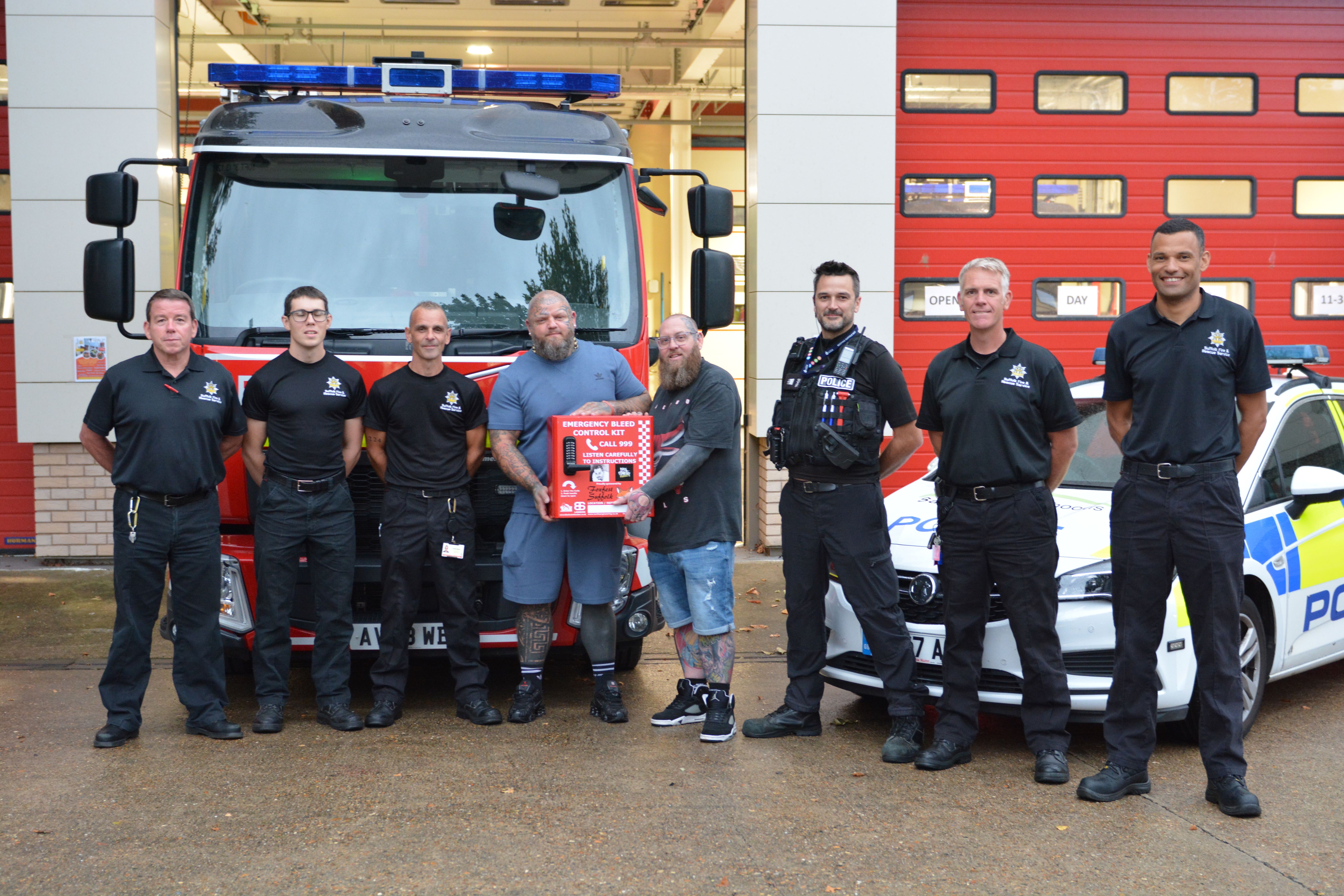 Paul Stansby and Jamie Hart of the Be Lucky Anti-Crime Foundation with firefighters and police officers