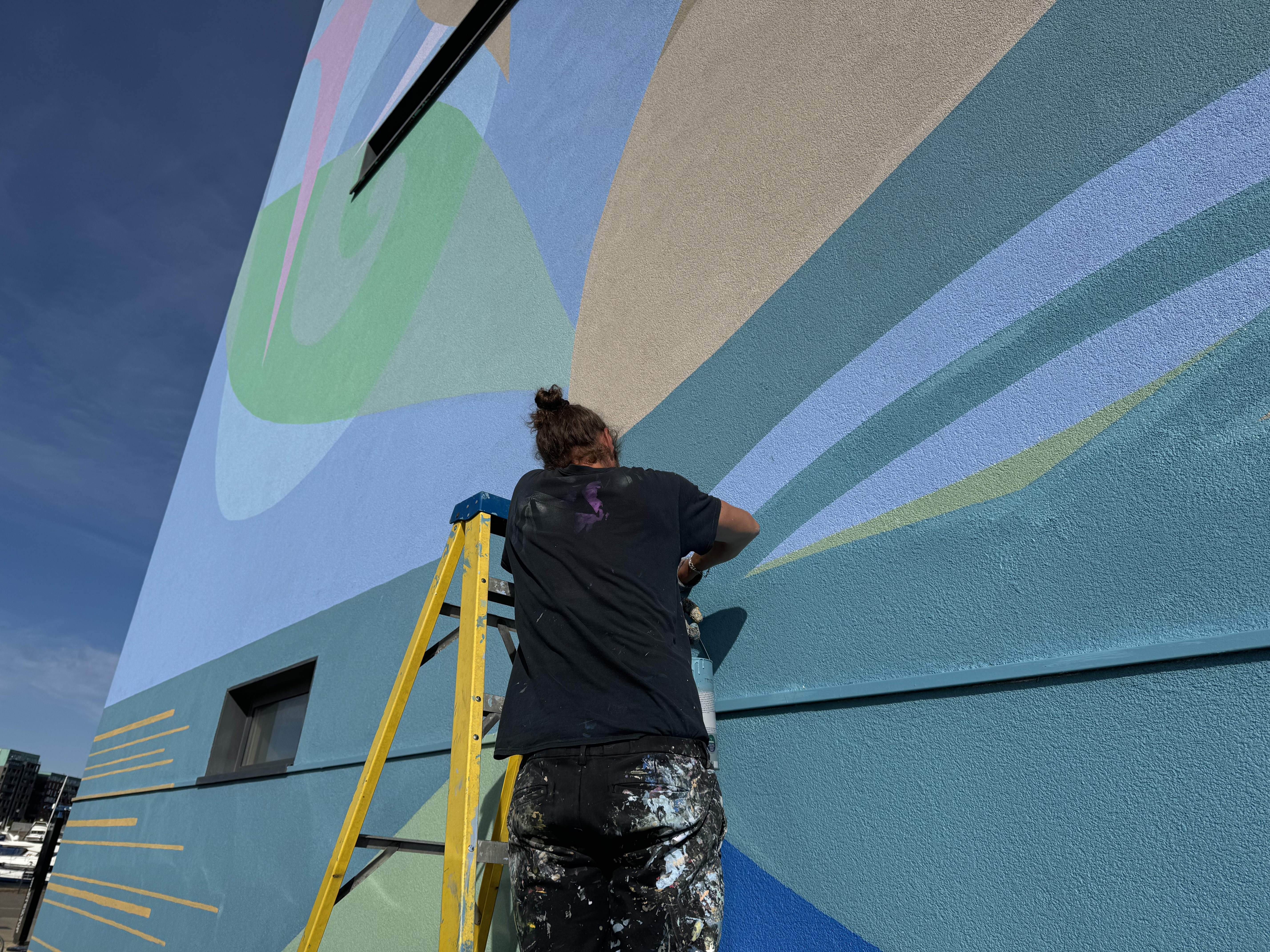 International street artist and mural painter ATMA finishing the mural on the James Hehir building in Ipswich