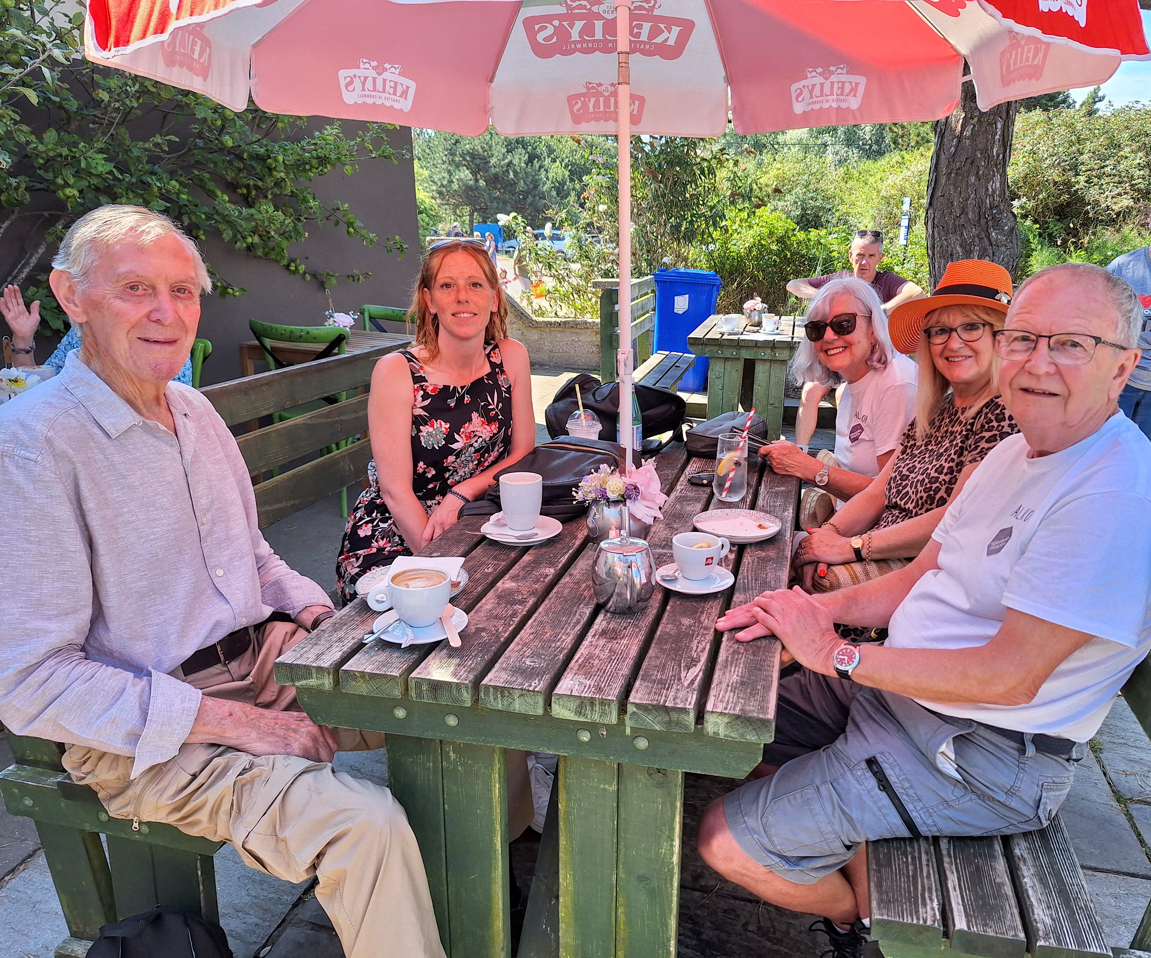 Group enjoying cakes and hot drinks