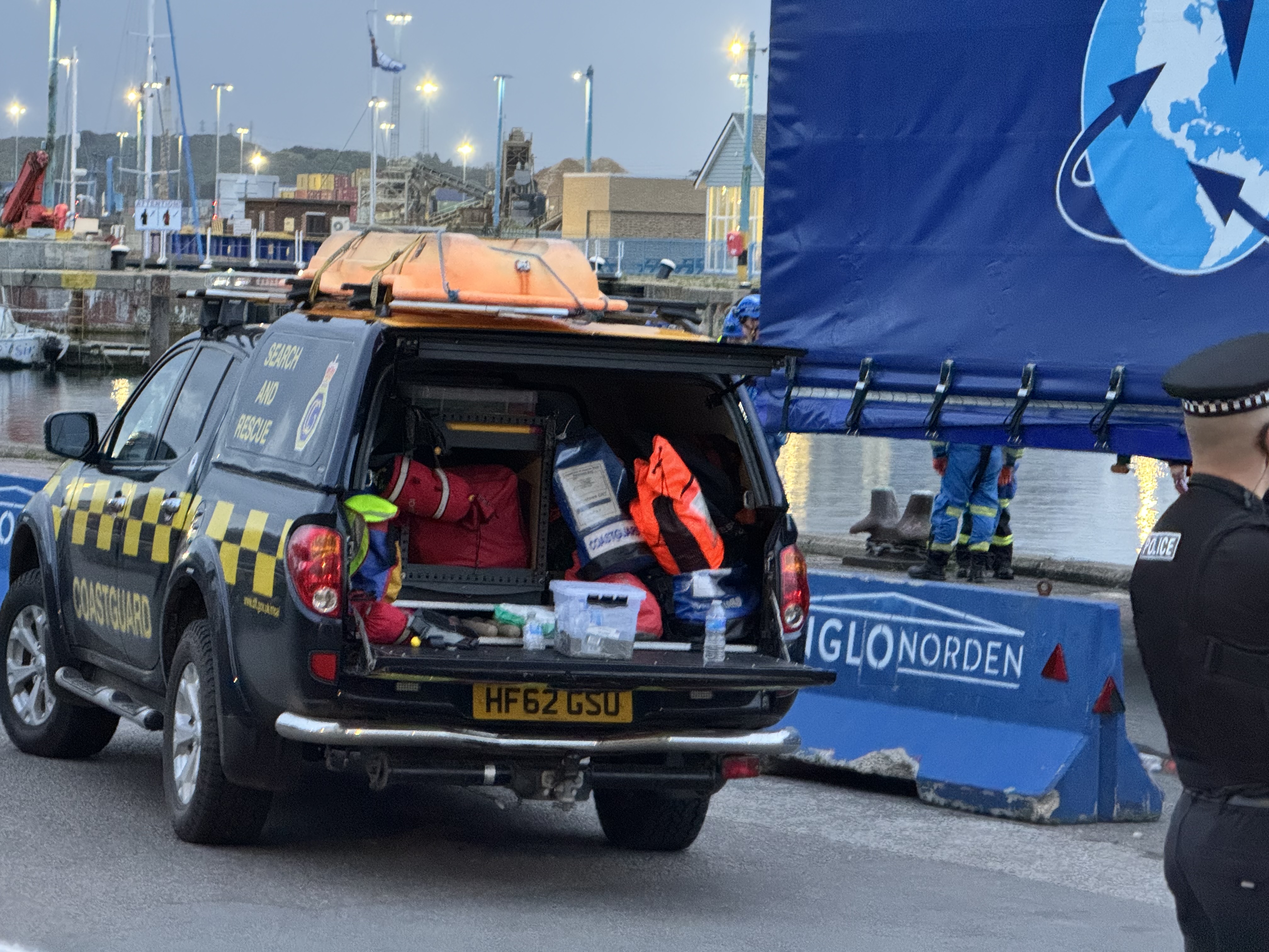 Rescue teams can be seen operating along the water edge