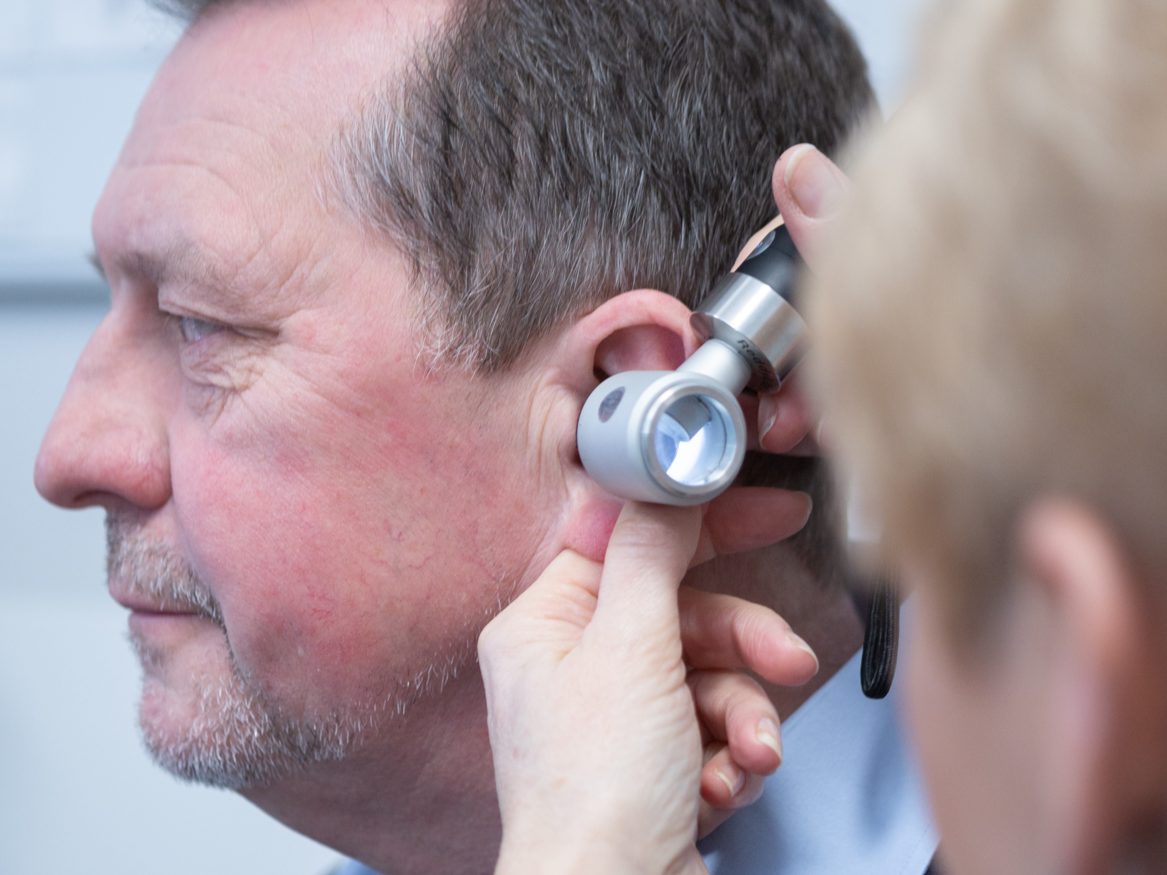 Karen Finch performing otoscaopy on a patient prior to earwax removal treatment