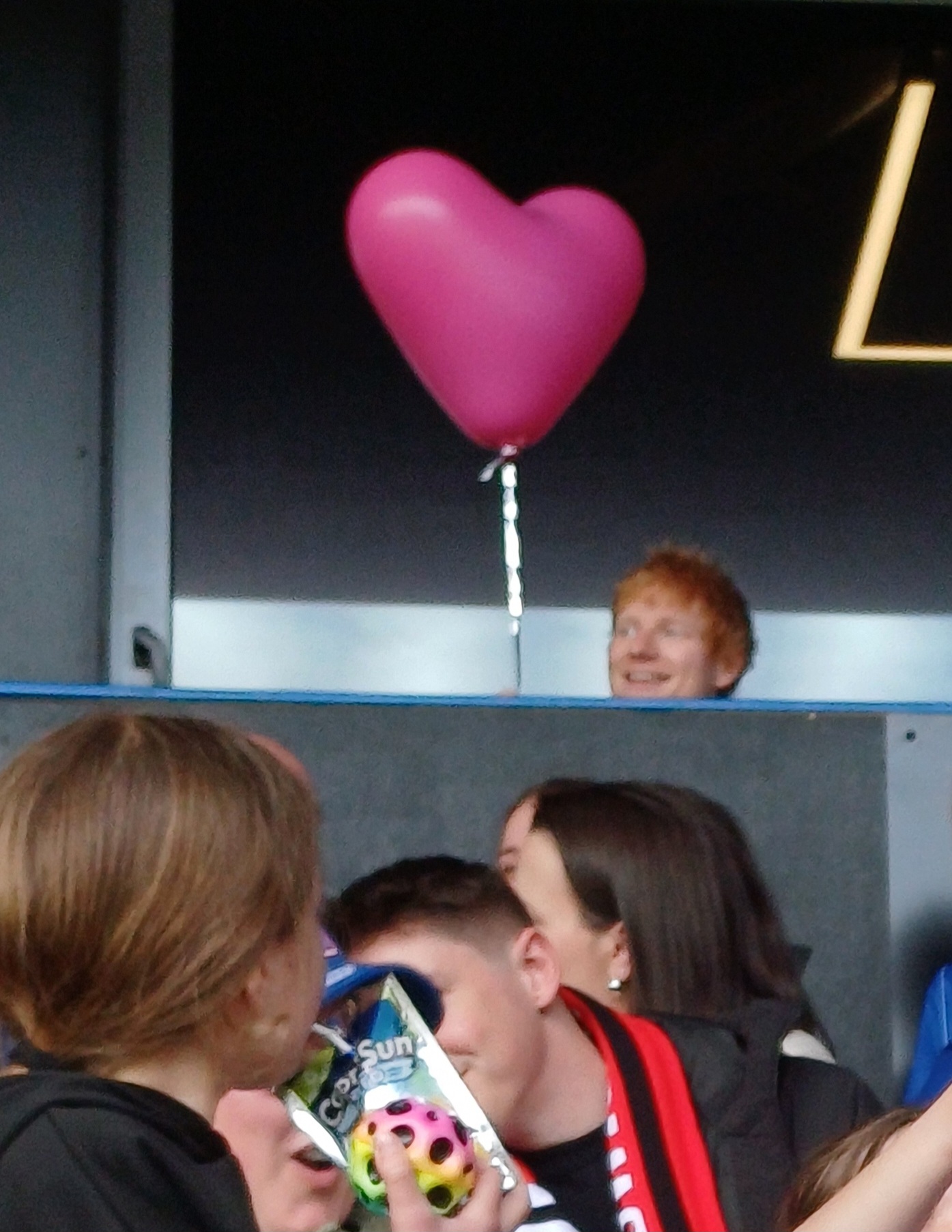 Ed Sheeran holding a heart balloon at Portman Road