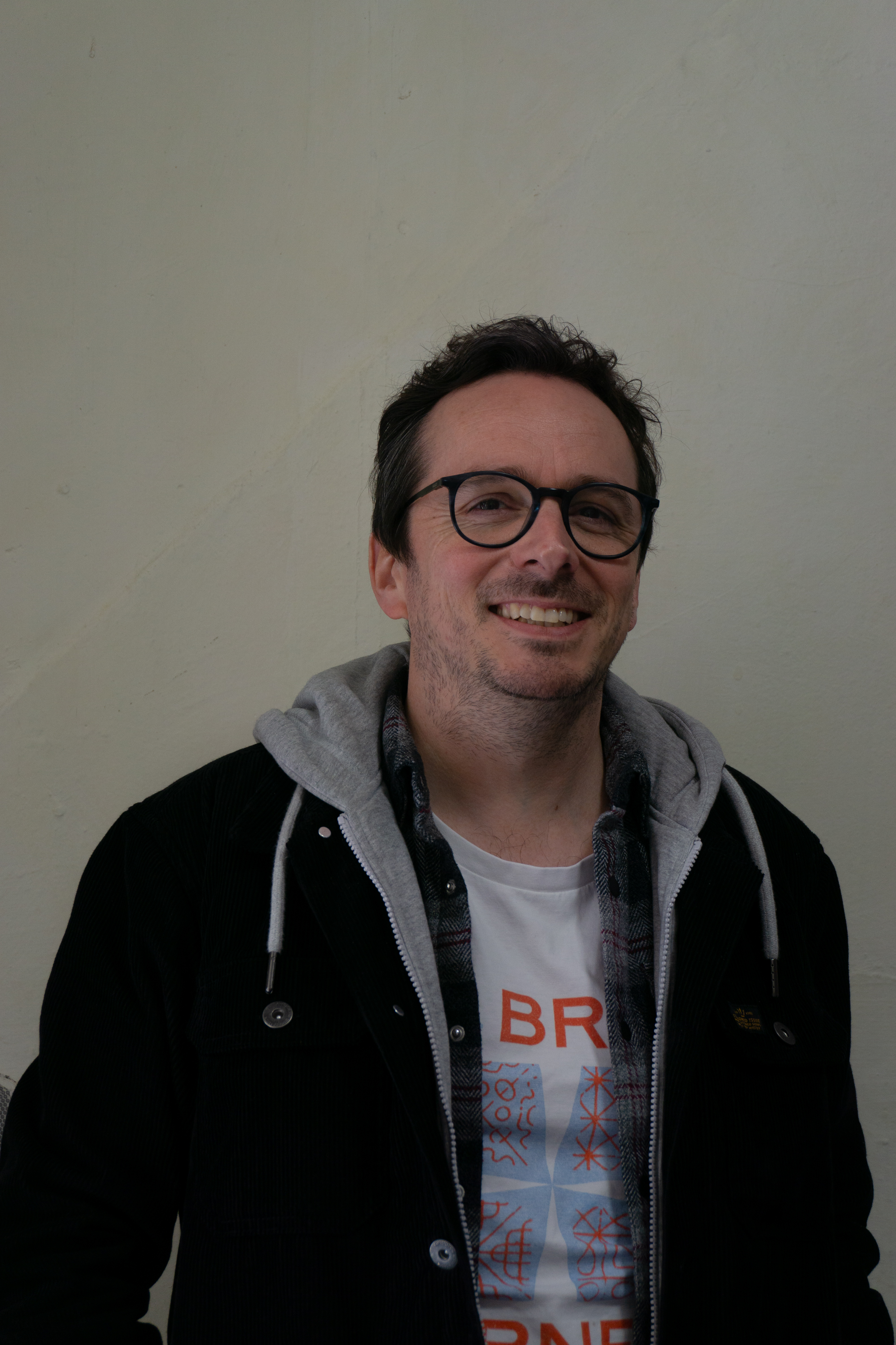 Joe Bailey, standing in front of a plain white background, smiling at the camera.