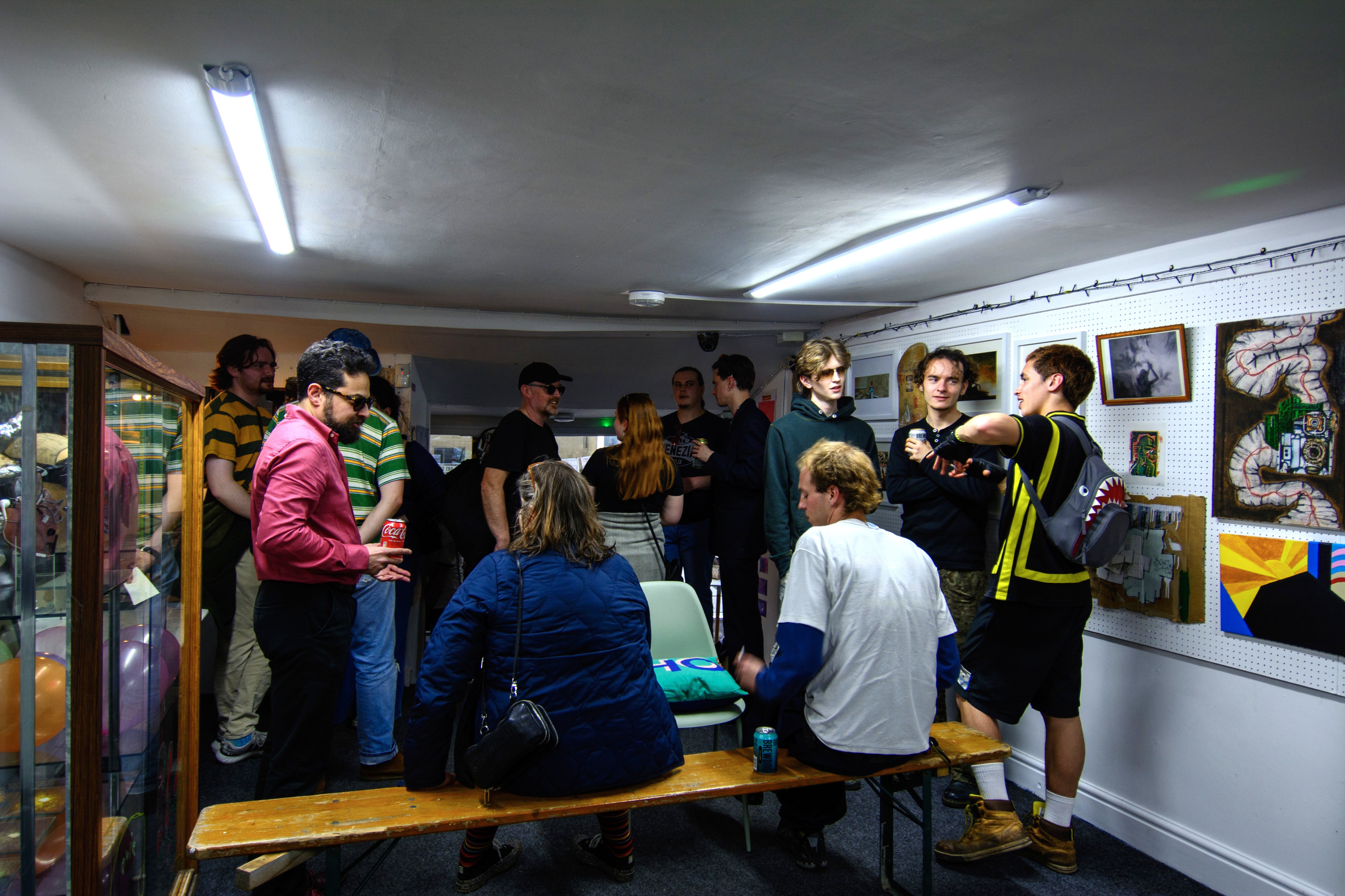 A group of artists and exhibition goers discuss the installation at The Hive