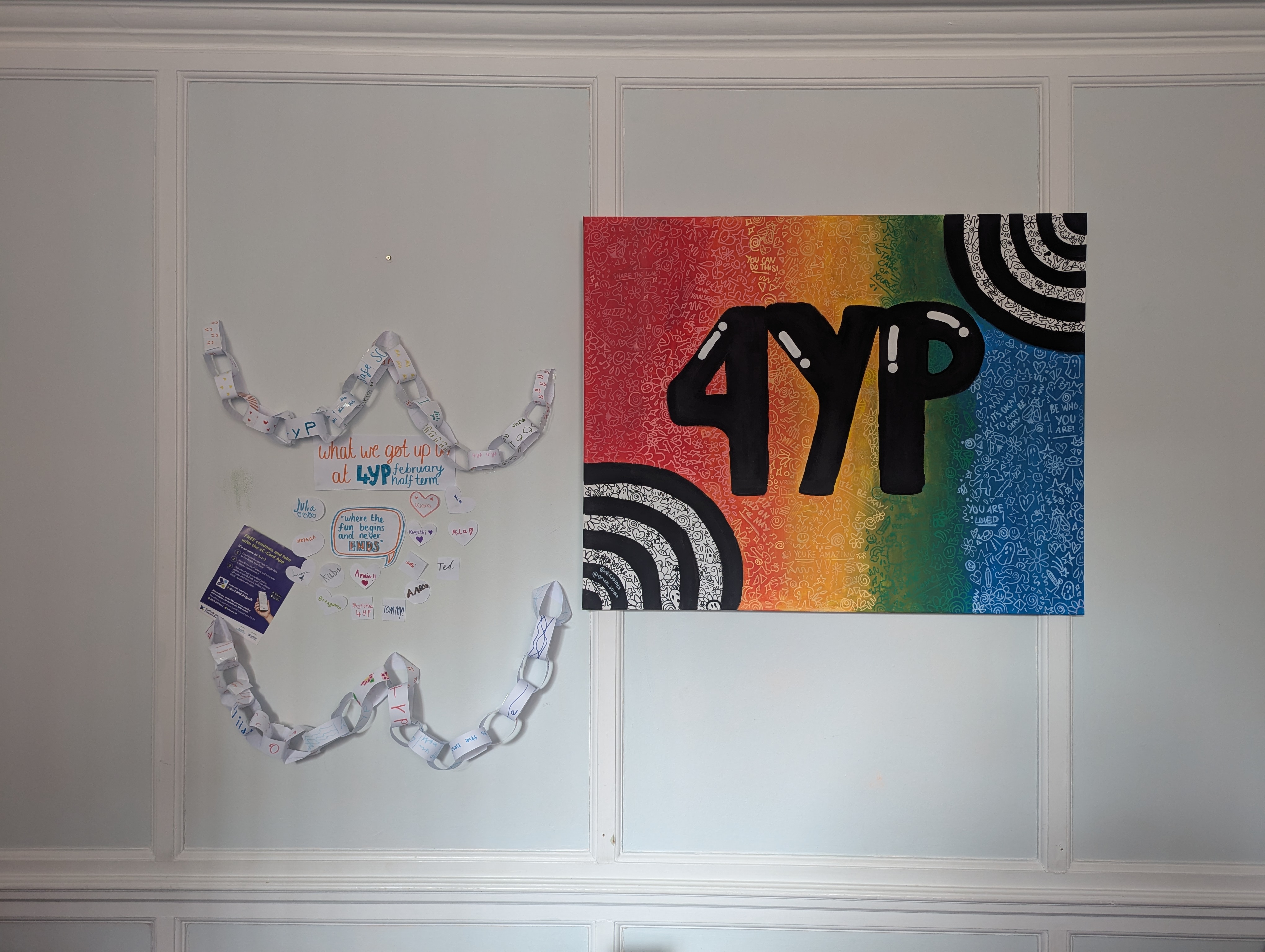A wall display showing 4YP branding and youth-created artwork including paper chains and colorful posters