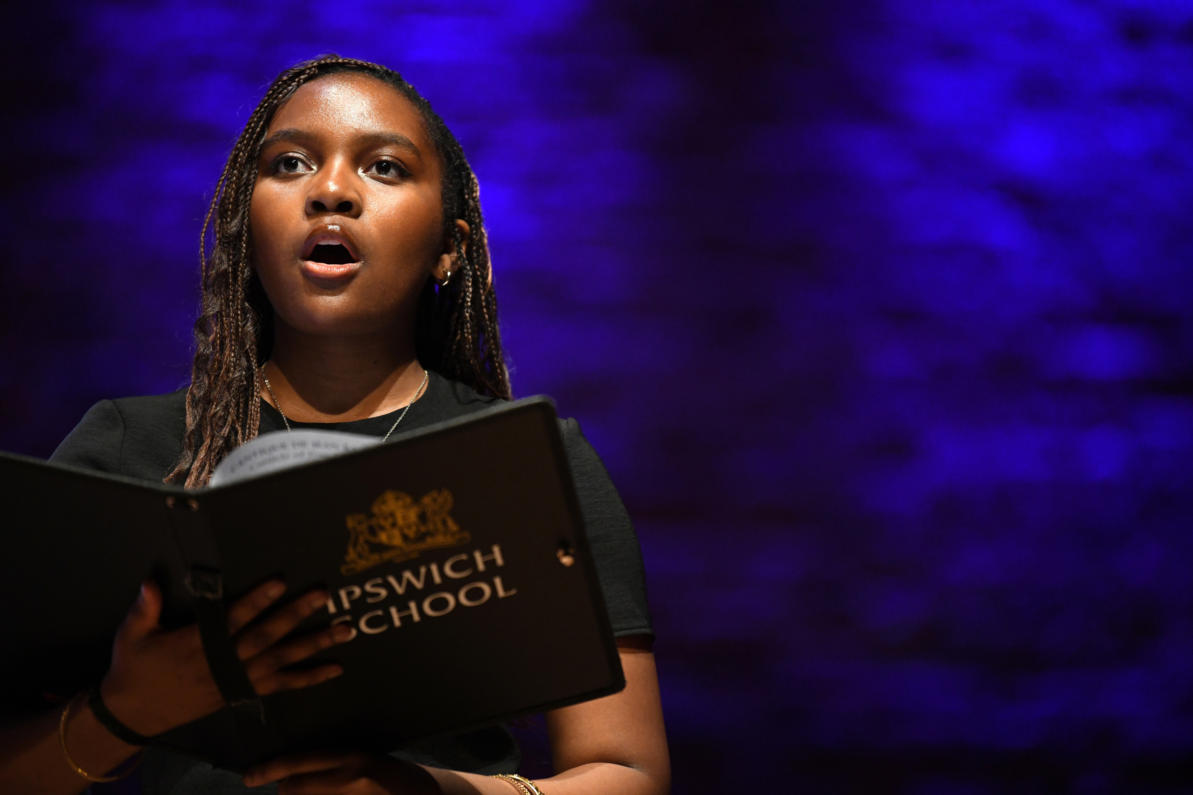 A young, black female Ipswich School student sining at Snape Maltings