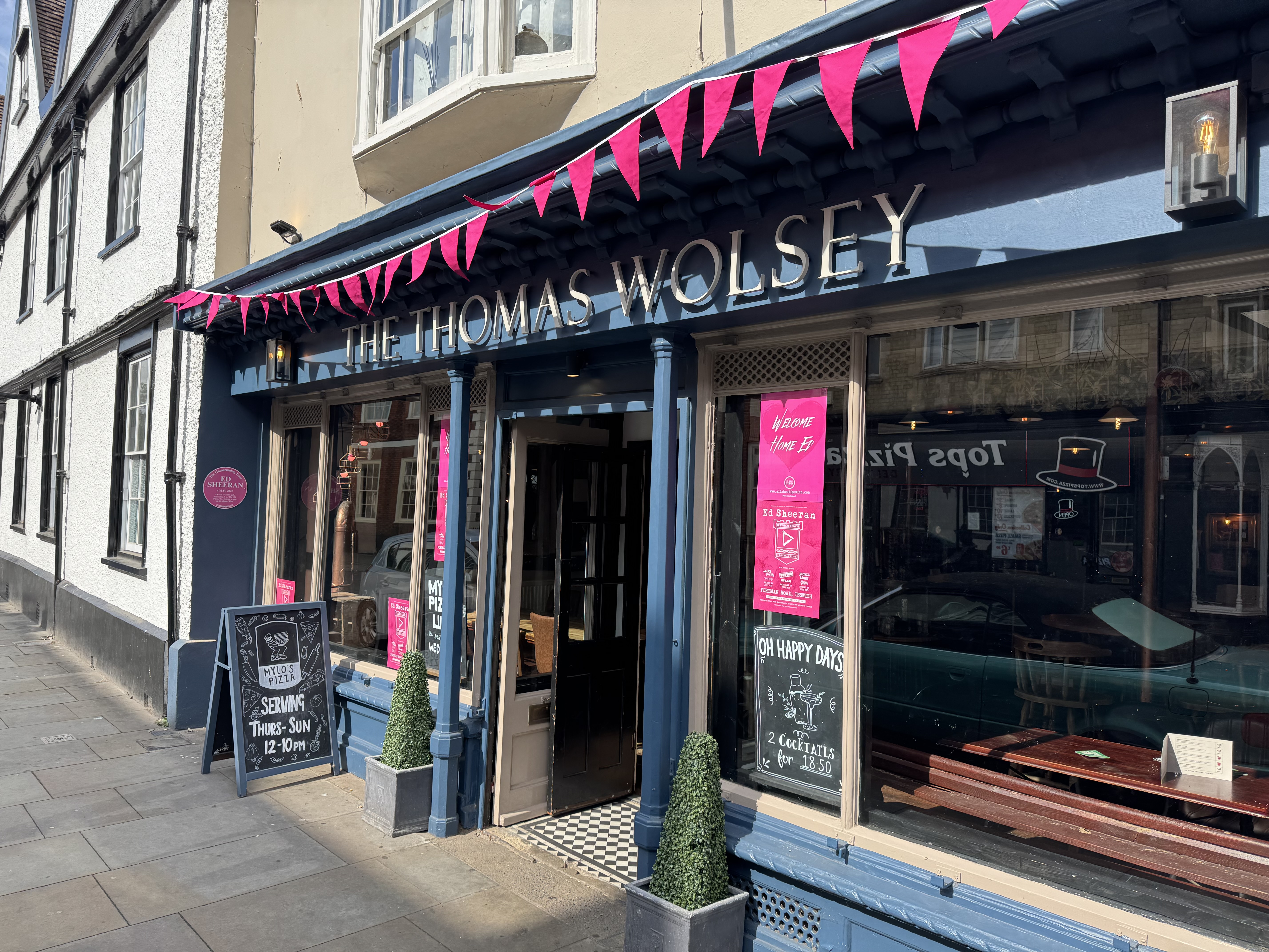 The Thomas Wolsey donning pink bunting, posters and plaque