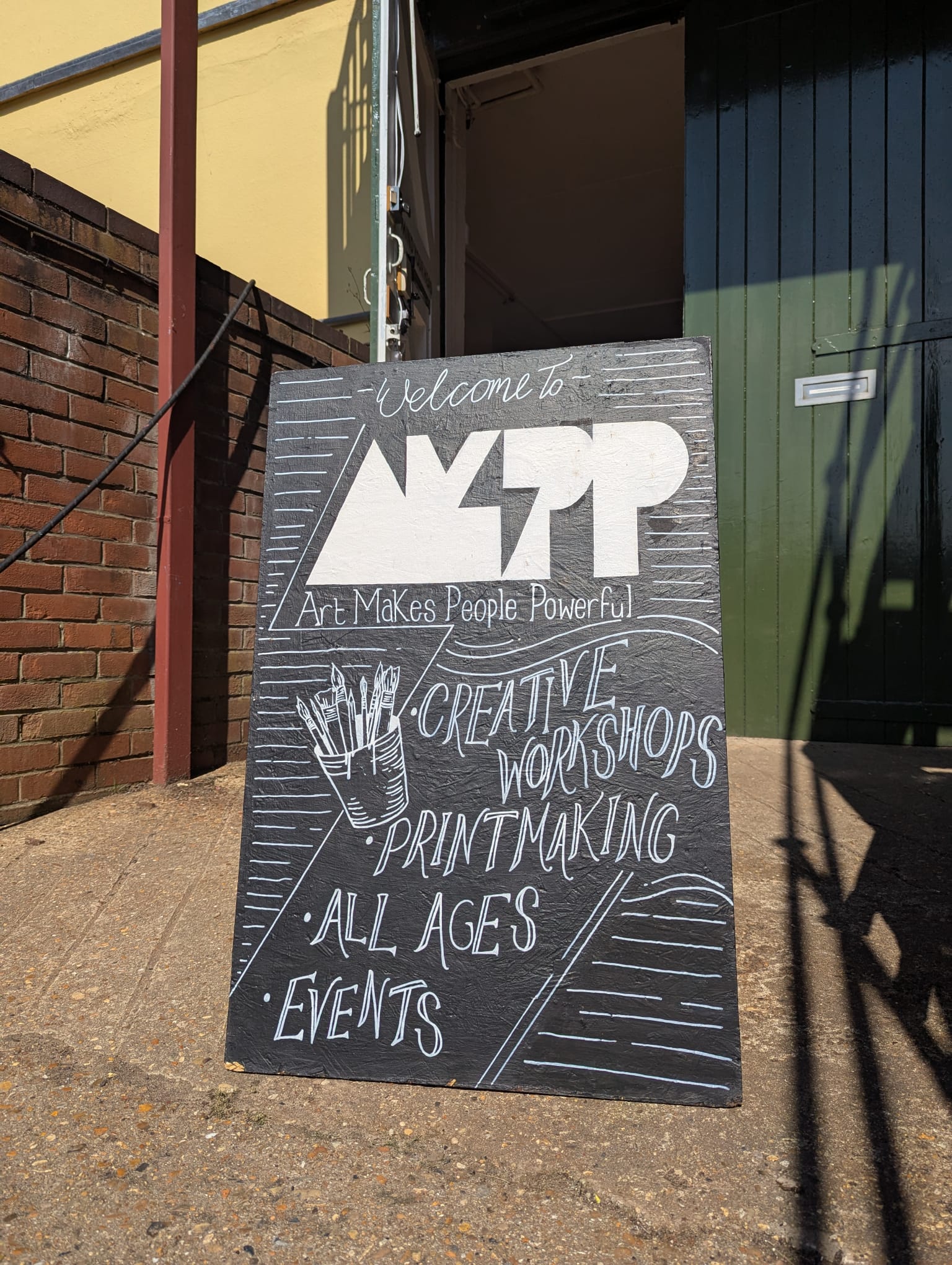 AMPP chalkboard painted and displayed outside the studio