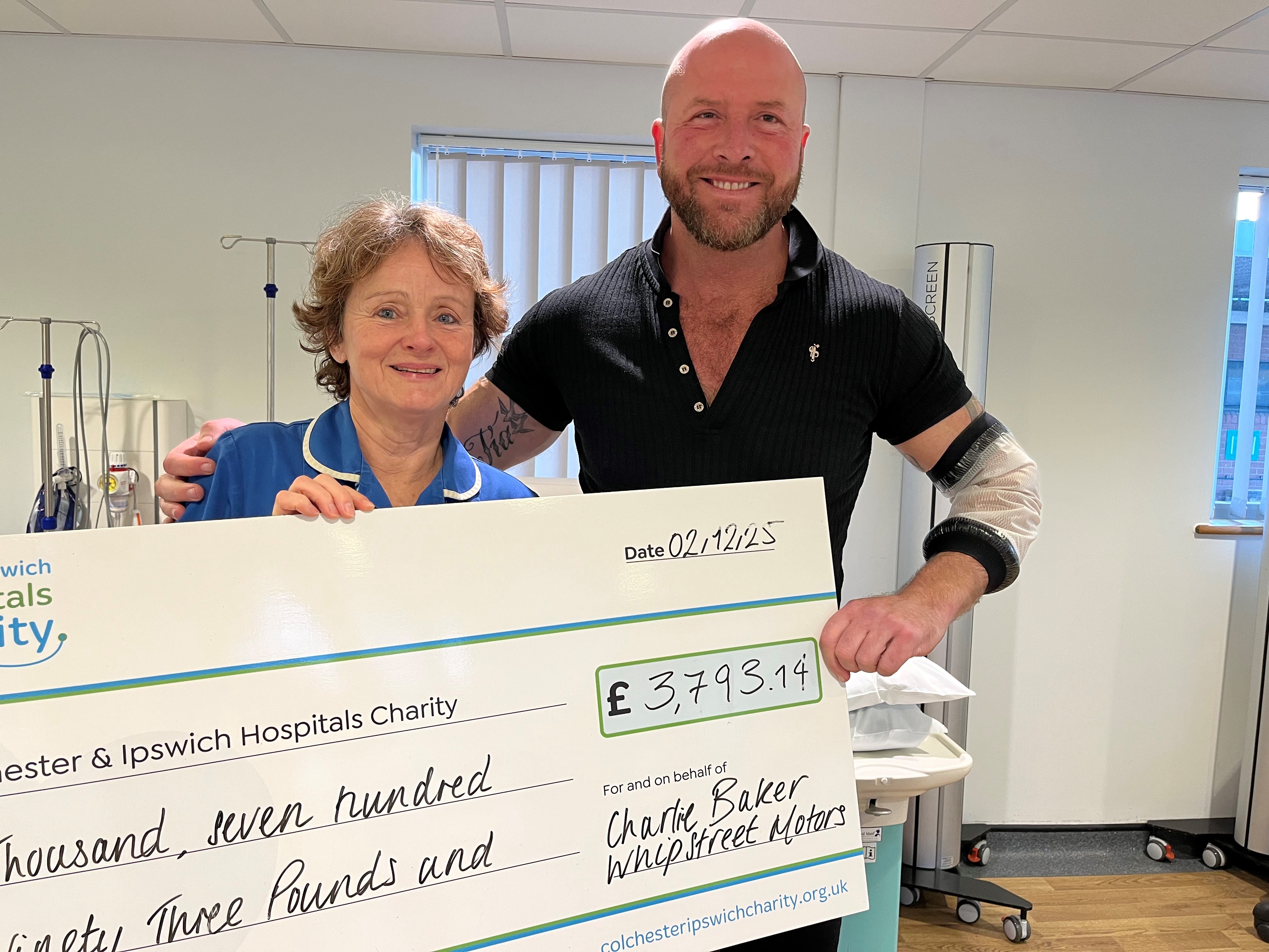 Two people holding large cheque in room