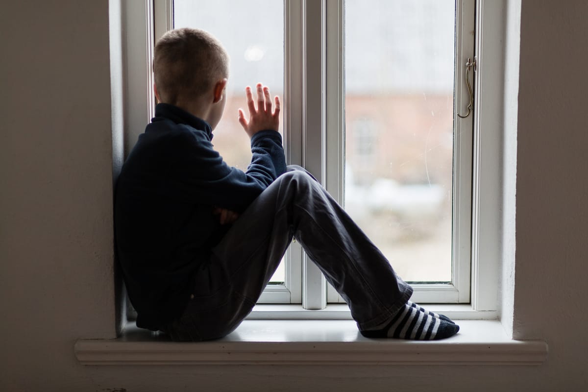 An autistic boy looking out the window