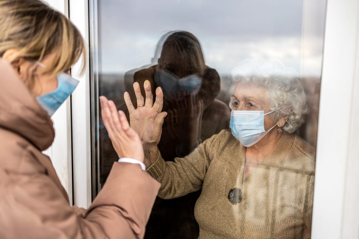 A woman visiting an elderly relative during COVID-19 lockdowns