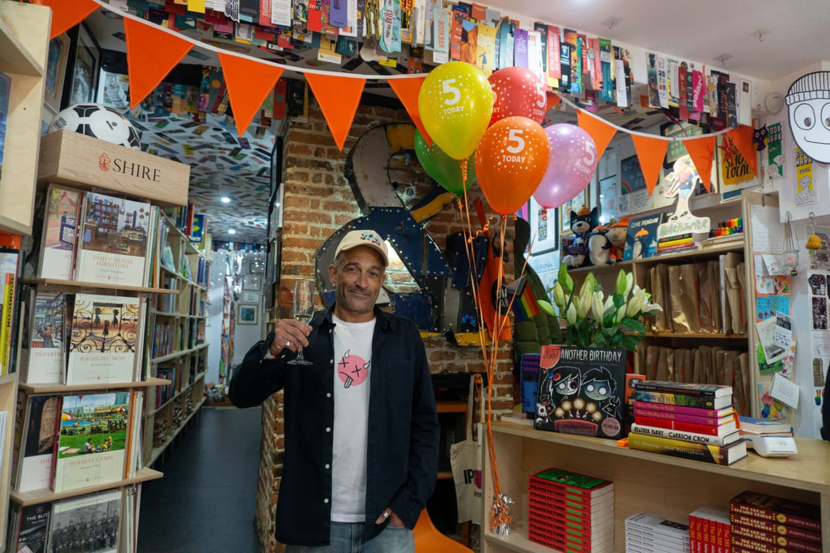 Book shop owner holding a glass celebrating 5 years of business
