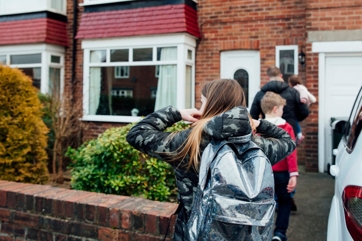 A father with his two children outside their home