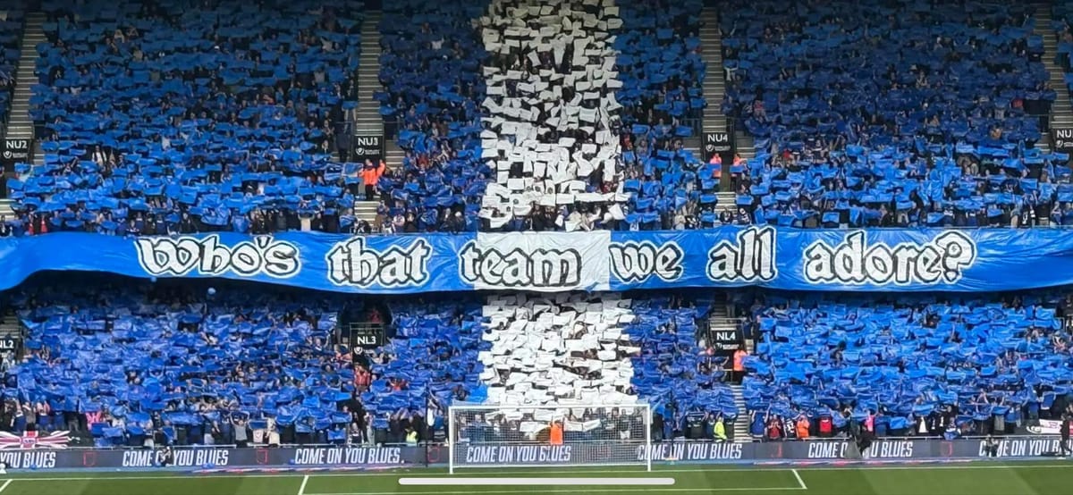 Fans at Portman Road holding up a sign reading "Who's that team we all adore?"