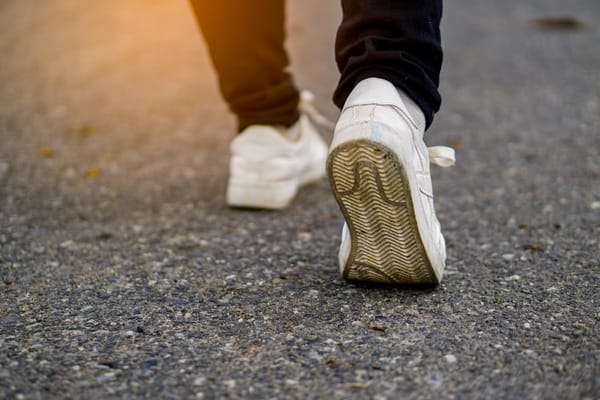 A close-up of a man walking on the pavement